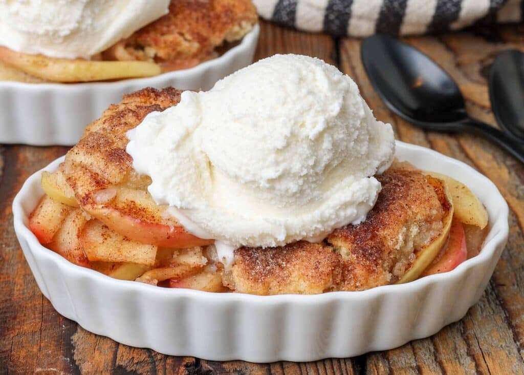 apple cobbler with ice cream in oval dishes