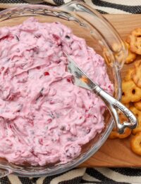 creamy cranberry dip with spreader and crackers surrounding it