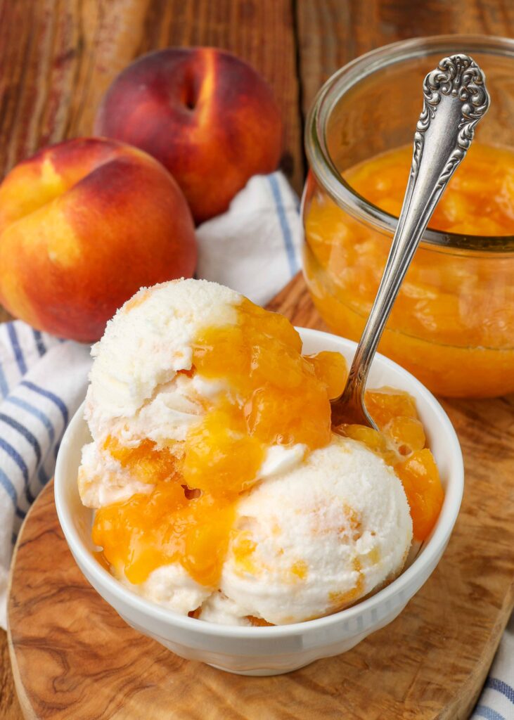 Peaches and cream ice cream, served in a wide white bowl with a silver spoon